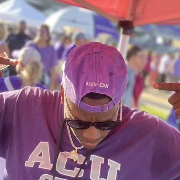 Fan wearing an Alon/DK branded cap with an ACU Football shirt